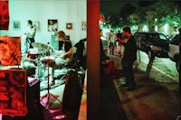 a group of people playing music on a street at night