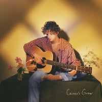 a man sitting on a bench with an acoustic guitar